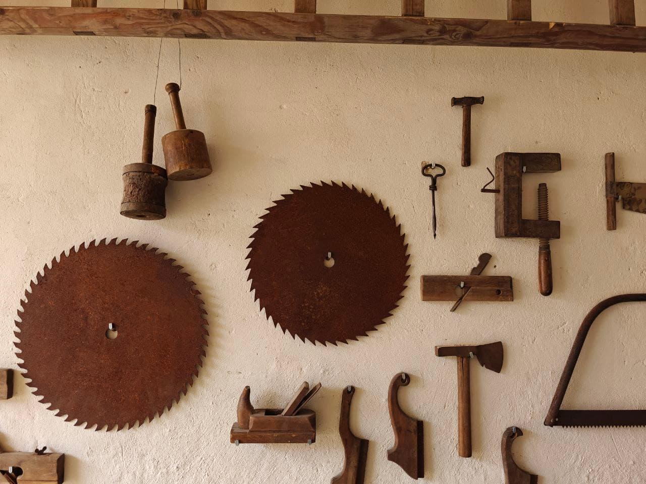 Wand mit historischen Tischlerwerkzeugen wie Hobeln, Sägen, Zwingen und Feilen in der Tordurchfahrt