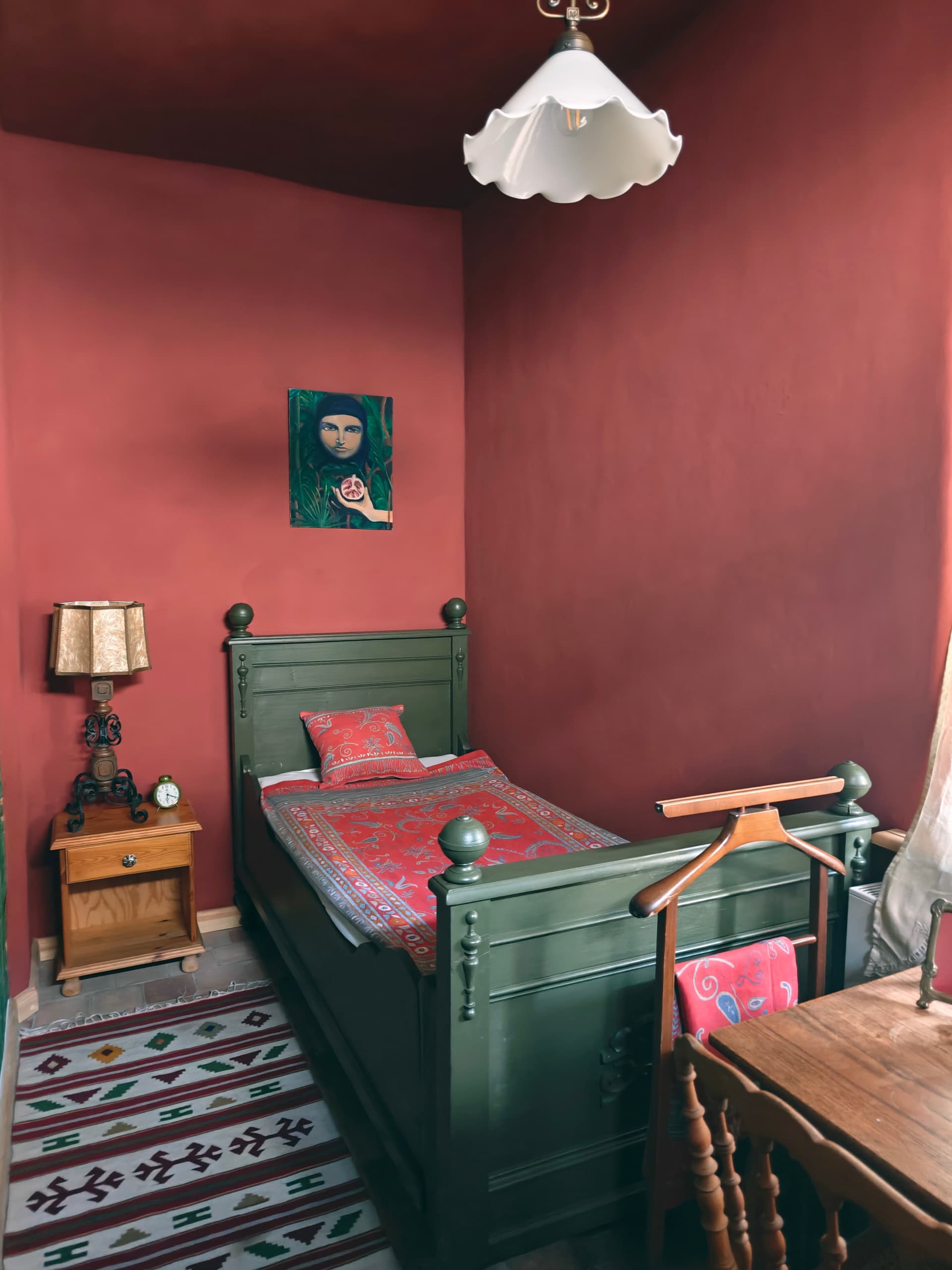 Schlafzimmer 2 mit olivgrünem Holzbett in weinroter Lehmstube, Orientläufer, Ölgemälde und Herrendiener